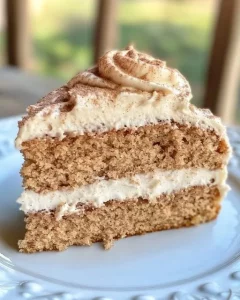 Slice of moist applesauce cake with cinnamon cream cheese frosting
