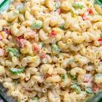 A colorful bowl of honey mustard pasta salad with fresh vegetables