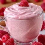 Delicious homemade raspberry mousse in a glass topped with fresh raspberries