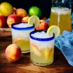 A refreshing glass of Tipsy Peach Lemonade garnished with peach slices.